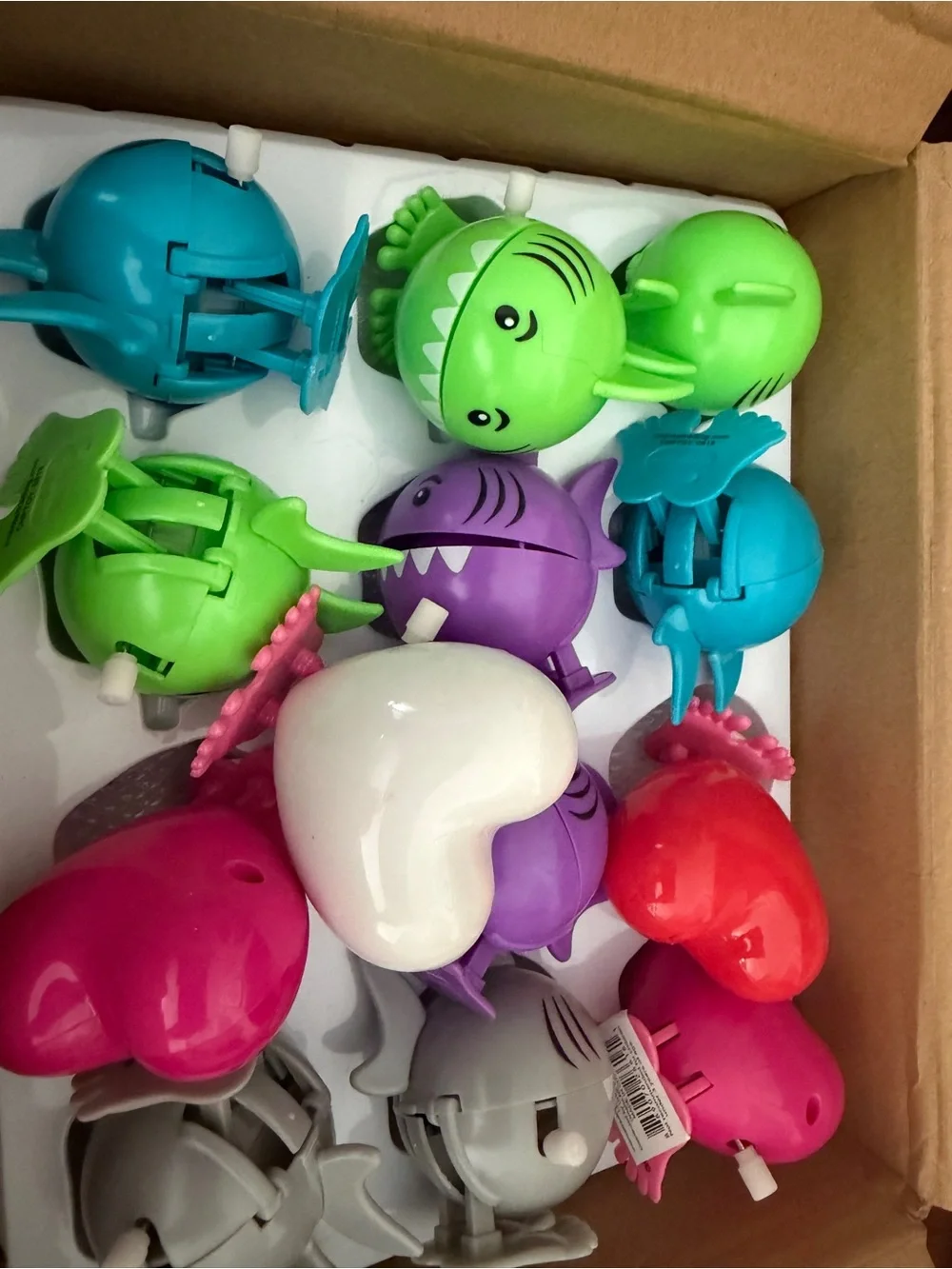 Assorted colors of sharks and hearts wind up toys .